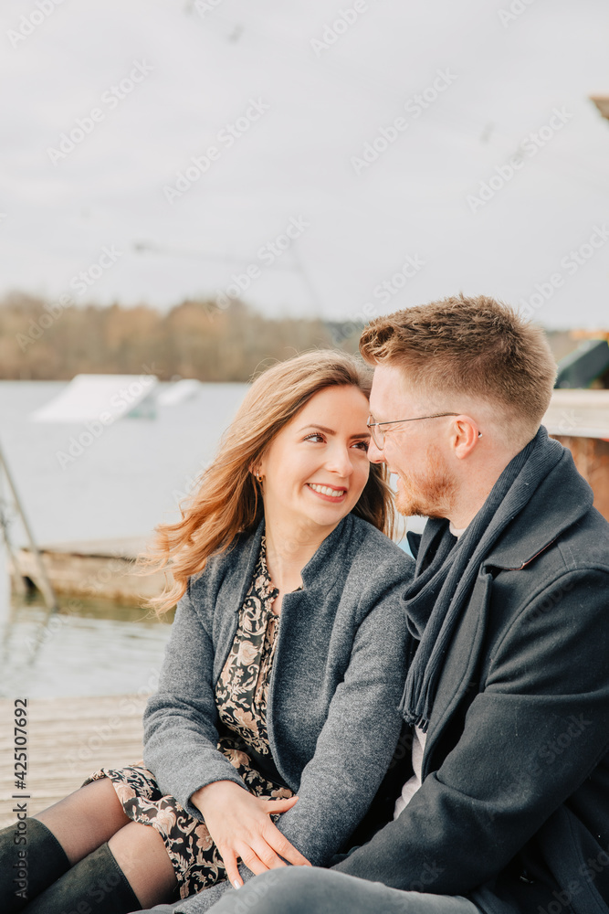 Young couple in love standing on the lake shore. Couple photos in spring. 