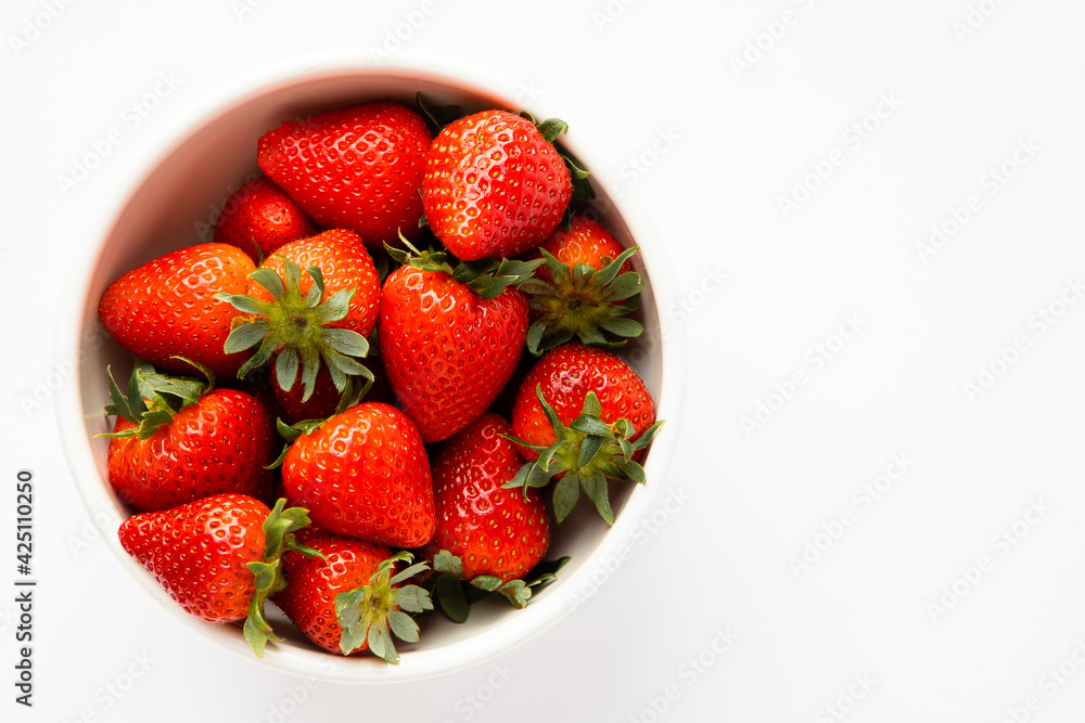 Red strawberries in a white bowl, plain background Red strawberries in a white bowl, plain background