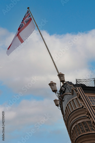 A white ensign flag flying on the back of HMS Victory