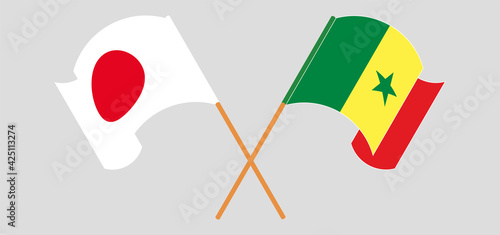 Crossed and waving flags of Japan and Senegal