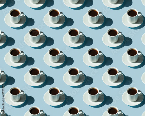 Obraz na płótnie Rhythmic pattern from cups with coffee on a blue background. w salonie