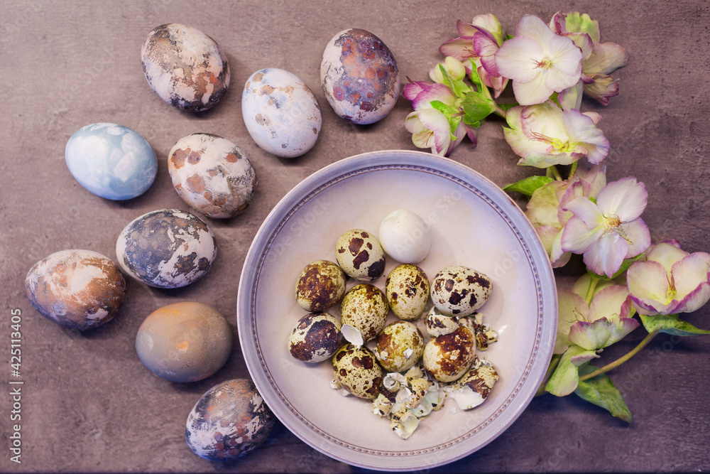 Naturally colored Easter eggs with onion skin and hand-painted with fresh flowers on concrete background Naturally colored Easter eggs with onion skin and hand-painted with fresh flowers on concrete background