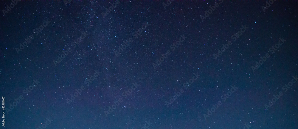 Obraz premium Panorama blue night sky on dark background.Universe filled with stars, nebula and galaxy with noise and grain.Photo by long exposure and select white balance.selection focus.amazing.