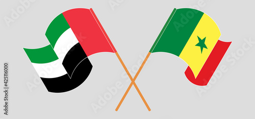 Crossed and waving flags of the United Arab Emirates and Senegal