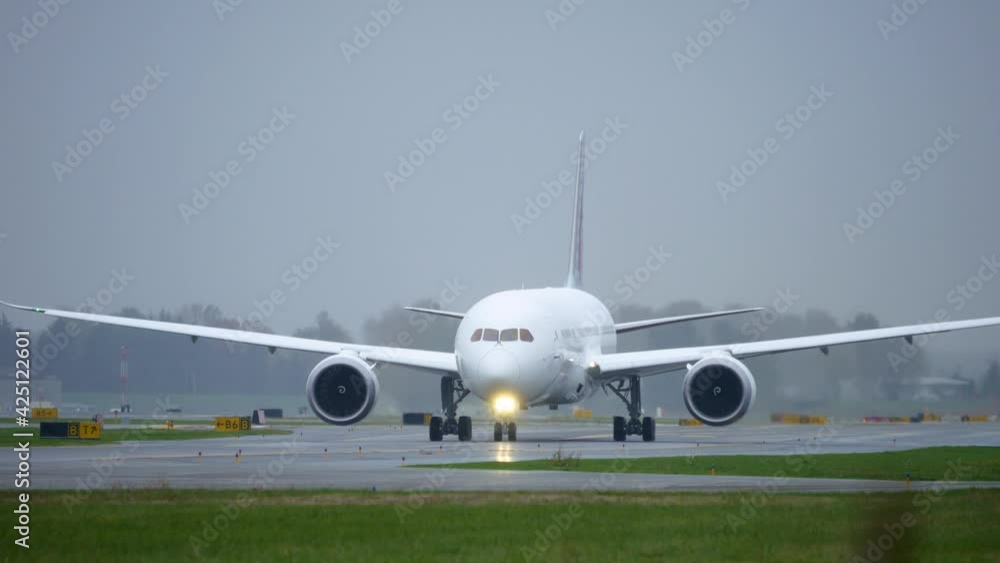 Close-up of widebody commercial airplane taxiing on the taxiway towards the runway to take off from the airport. Close-up of widebody commercial airplane taxiing on the taxiway towards the runway to take off from the airport.