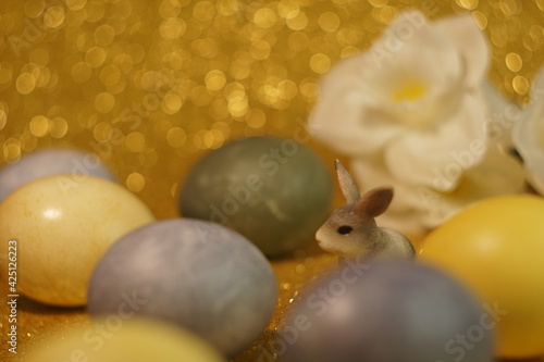 bunny figurine on Easter eggs in trendy colors - yellow and gray