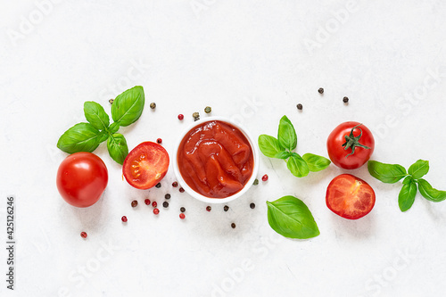 Homemade tomato sauce with fresh aromatic basil, cherry tomatoes, peppercorn and garlic on white marble background. Culinary blog banner concept