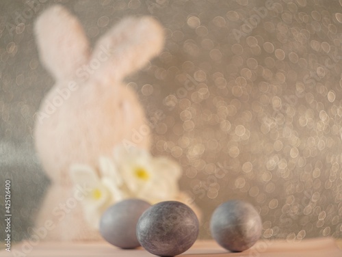 bunny figurine on Easter eggs in trendy colors - yellow and gray