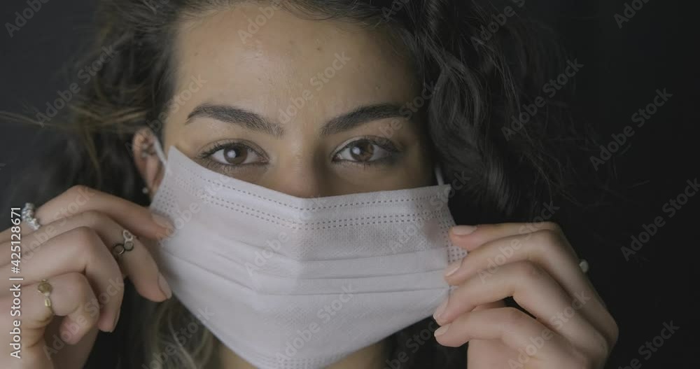 Face portrait of smiling young long haired woman is using face mask for protect herself from virus. Epidemic time, illness and health care concept. Face portrait of smiling young long haired woman is using face mask for protect herself from virus. Epidemic time, illness and health care concept.