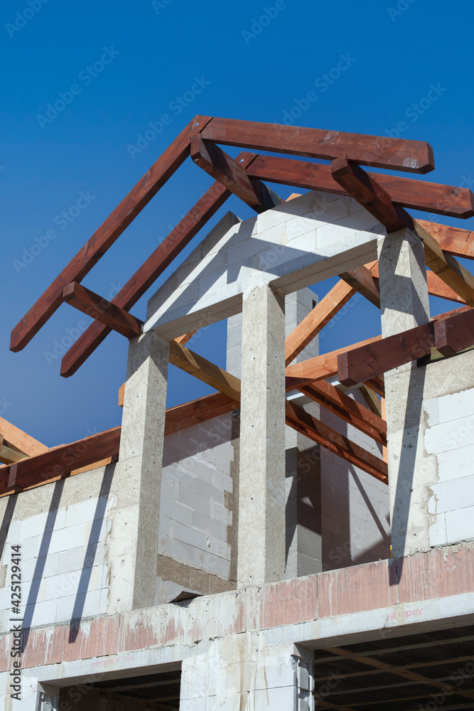 A new home under construction, detail. Light brick and wooden roofing beams