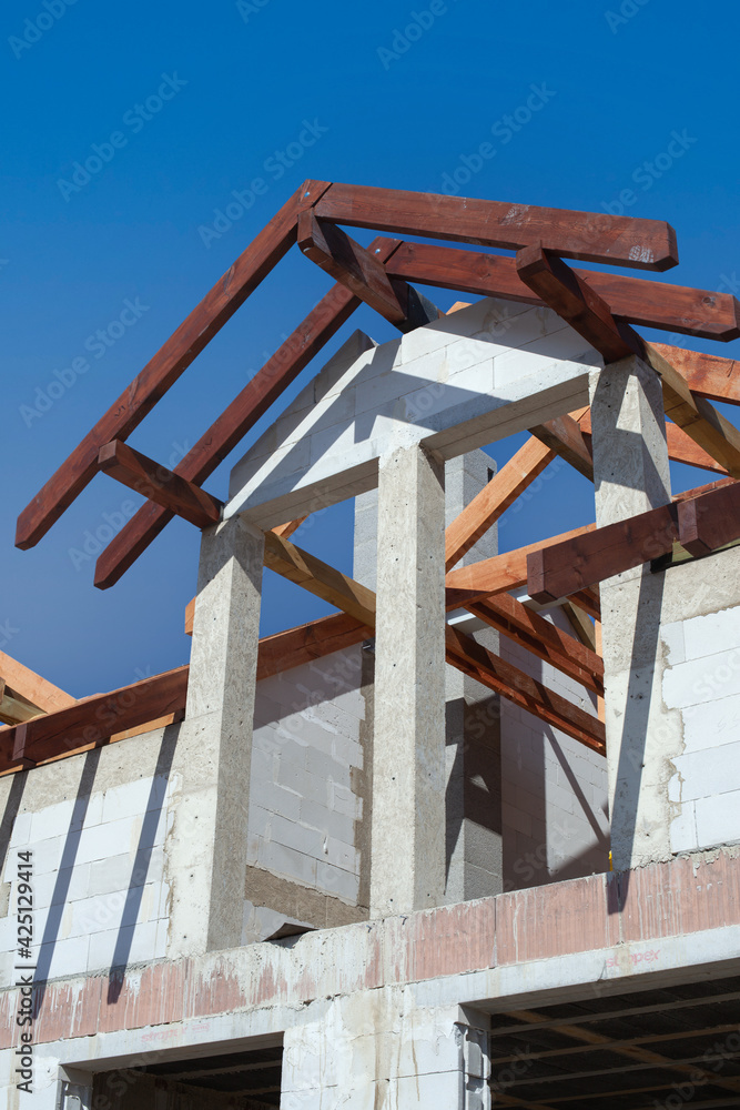 A new home under construction, detail. Light brick and wooden roofing beams A new home under construction, detail. Light brick and wooden roofing beams
