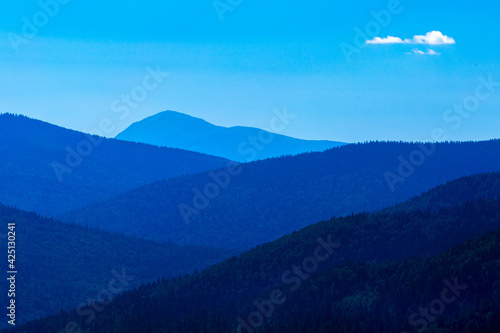 Fototapeta Naklejka Na Ścianę i Meble -  Mountain landscape, mountains covered with coniferous trees, in the background the peak of the highest mountain.