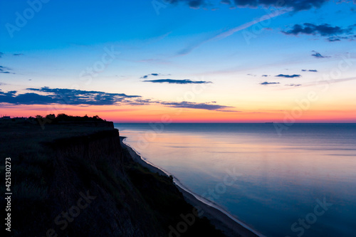 Seascape before sunrise with the coast in the foreground.