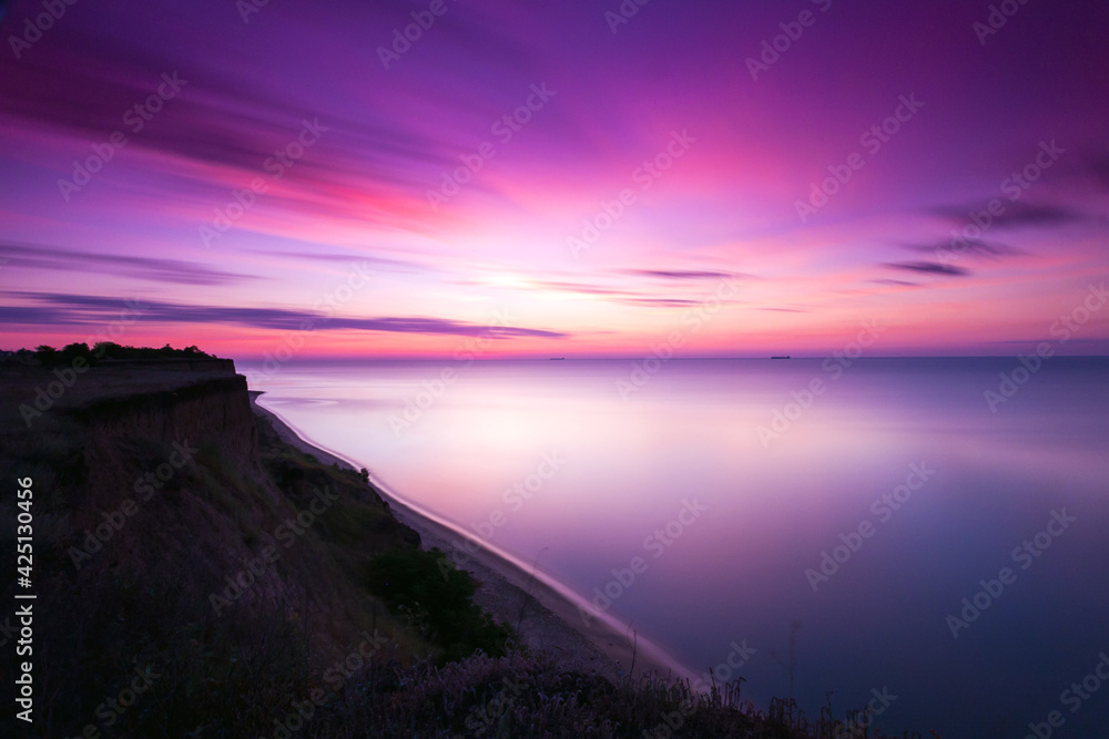 Seascape before sunrise with the coast in the foreground