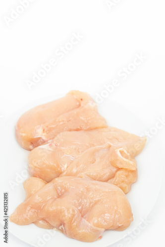 Raw Chicken Breasts on the plate above white background