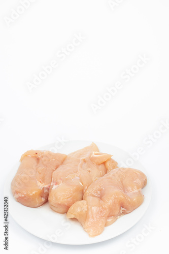 Raw Chicken Breasts on the plate above white background