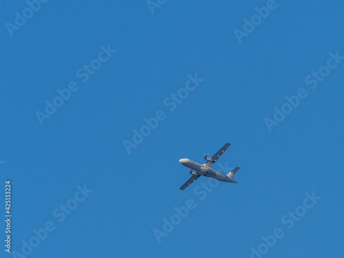  white propeller plane flies in the blue sky