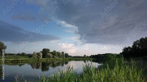 Shore of calm river at a cloudy day