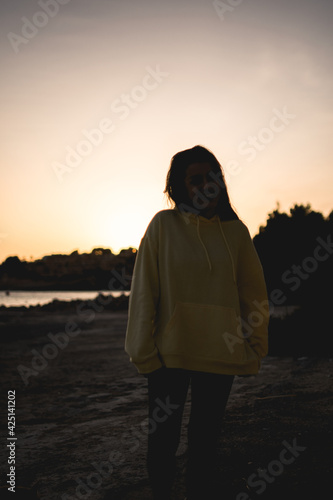 Mujer puesta de sol con sudadera amarilla © Omar