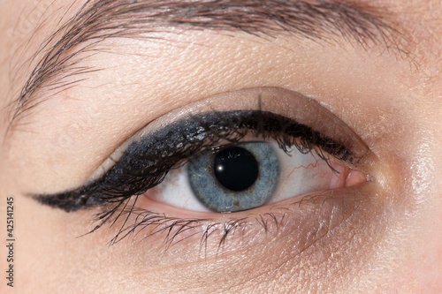 Detail of a calm human eye, visible iris, woman, eye lines, flash
