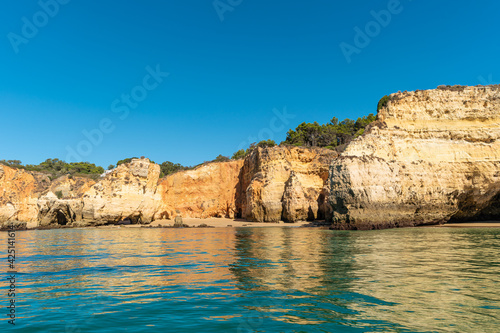 Natural caves and beach  Algarve Portugal. Rock cliff arches of Seven Hanging Valleys and turquoise sea water on coast of Portugal in Algarve region