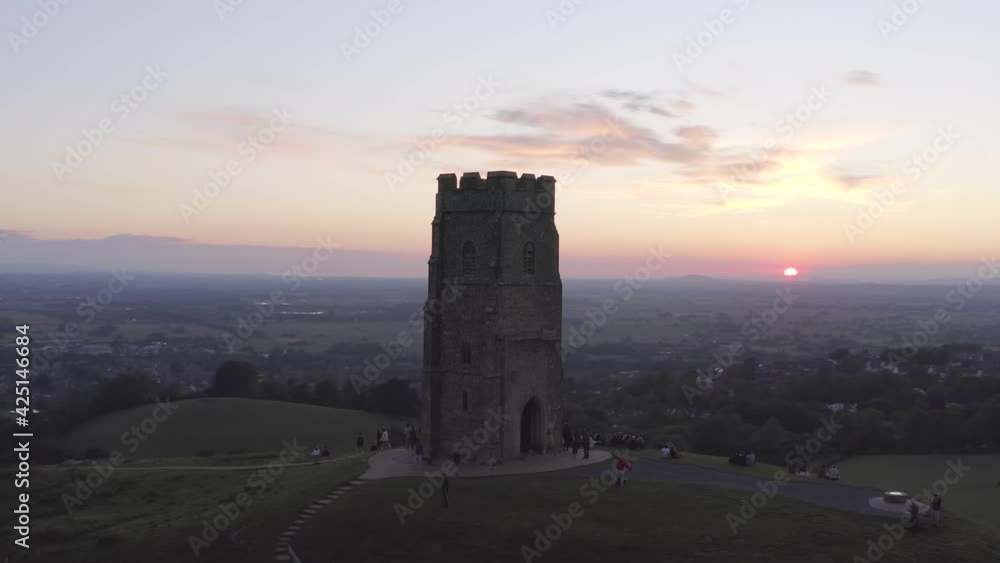 Sunset aerial orbiting the Glastonbury Tor close-up set against countryside and colourful skies in Somerset, United Kingdom Sunset aerial orbiting the Glastonbury Tor close-up set against countryside and colourful skies in Somerset, United Kingdom