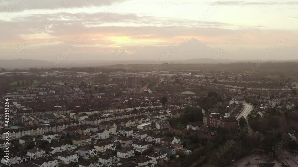 Aerial tracking shot of morning urban cityscape housing, roads and traffic under colourful morning sky in the United Kingdom Aerial tracking shot of morning urban cityscape housing, roads and traffic under colourful morning sky in the United Kingdom