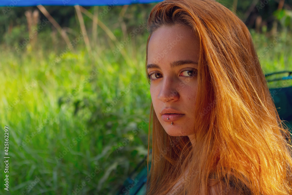 Redhead girl camping with grass background Redhead girl camping with grass background