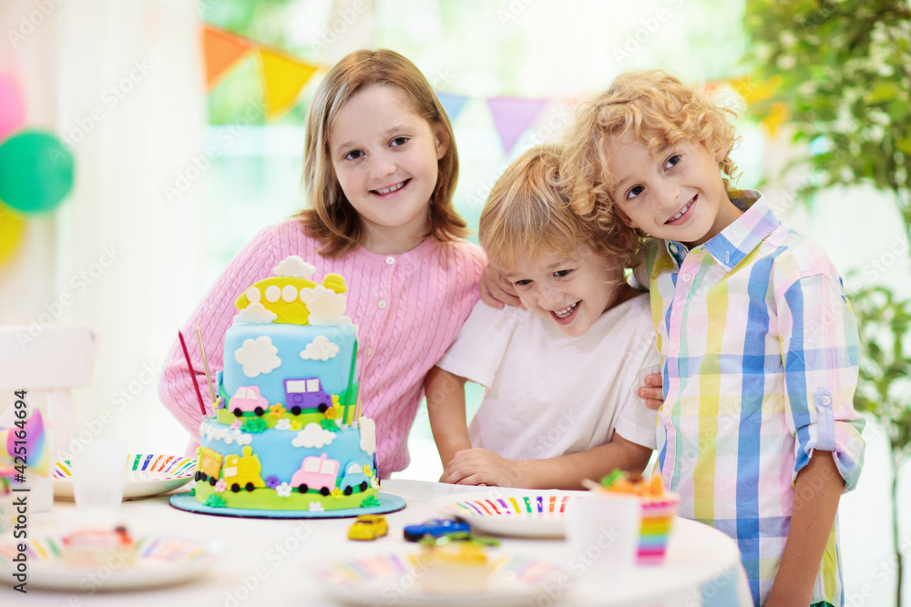 Kids birthday party. Child blowing out cake candle Kids birthday party. Child blowing out cake candle