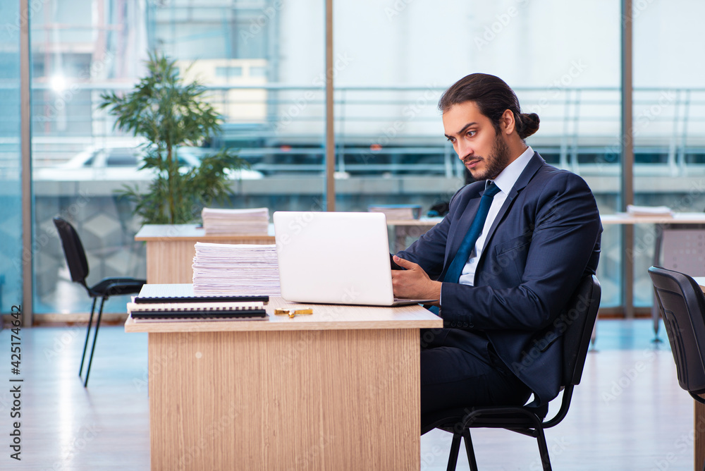 Young male employee working in the office Young male employee working in the office