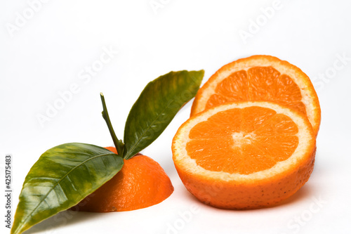 Fototapeta Naklejka Na Ścianę i Meble -  Cut Orange fruit with leaves isolated on white.