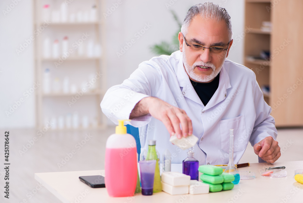 Old male chemist testing soap in the lab Old male chemist testing soap in the lab