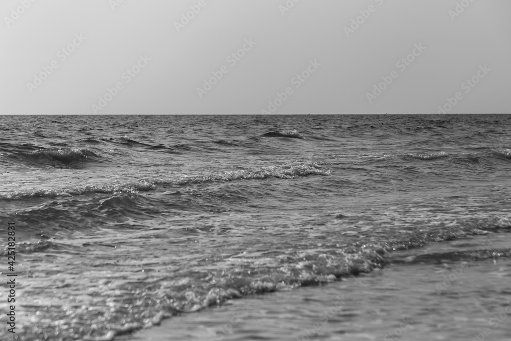 Soft wave of Black and white ocean on sandy beach. Background.