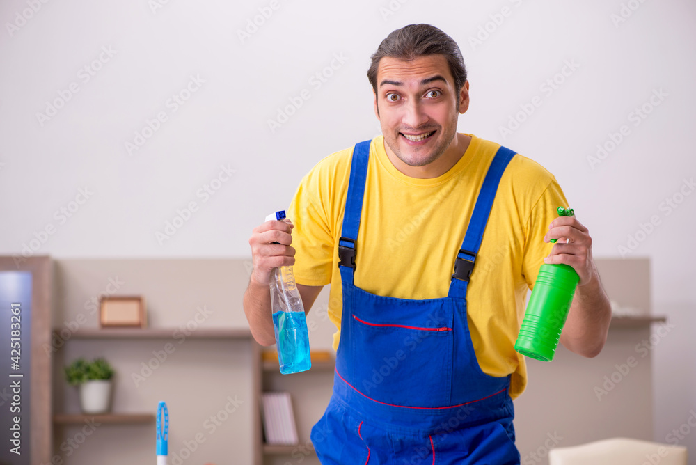 Young male contractor cleaning the house