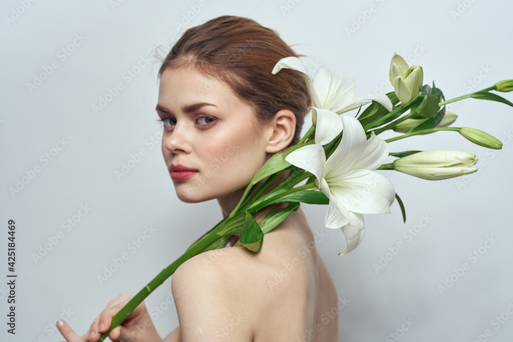 Beautiful woman naked shoulders bouquet flowers cosmetics clean skin Beautiful woman naked shoulders bouquet flowers cosmetics clean skin