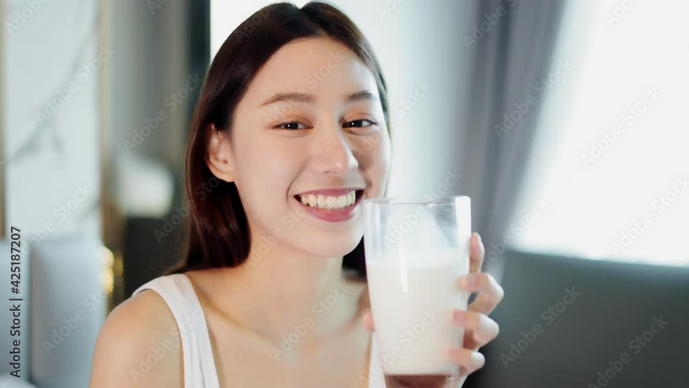 Asian young woman drinking milk.Beautiful Asian pregnant woman drink milk then smile and also looking at camera. Asian young woman drinking milk.Beautiful Asian pregnant woman drink milk then smile and also looking at camera.