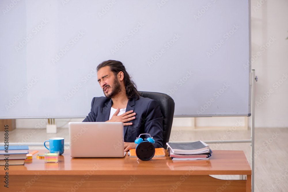 Young male teacher in the classroom Young male teacher in the classroom