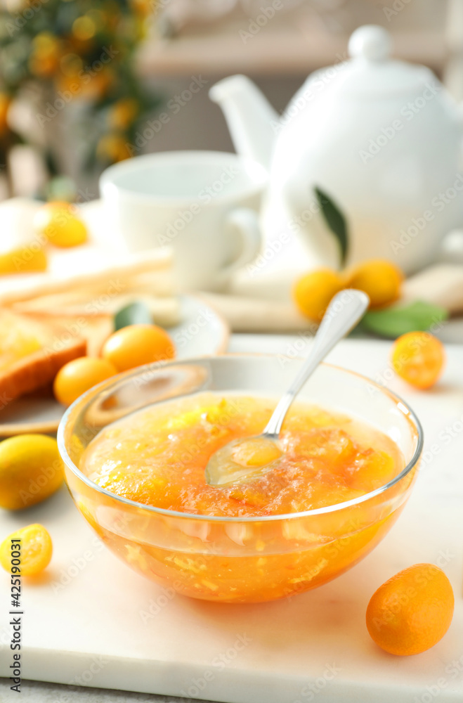 Delicious kumquat jam in glass bowl on white board Delicious kumquat jam in glass bowl on white board