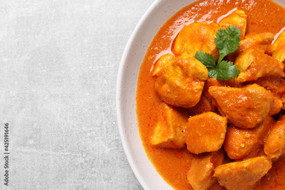 Bowl of delicious chicken curry on light grey table, top view. Space for text Bowl of delicious chicken curry on light grey table, top view. Space for text