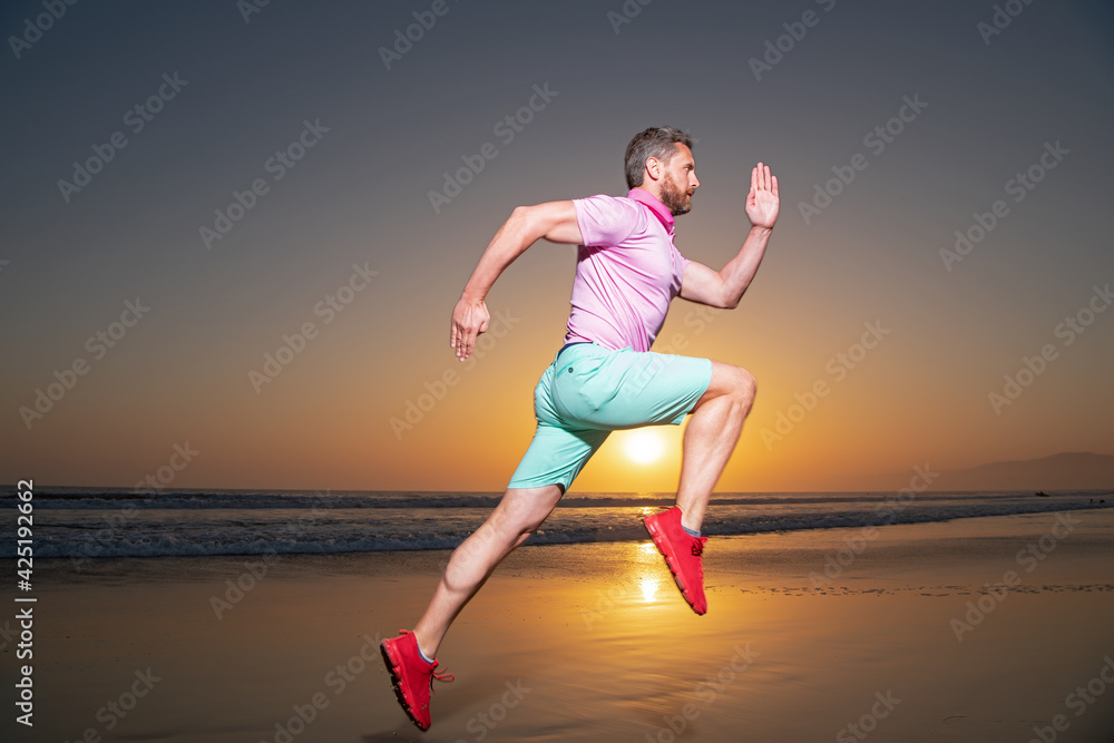 Athletic young man running in the nature. Fit man fitness model working outdoor by sea beach. Dynamic run movement. Athletic young man running in the nature. Fit man fitness model working outdoor by sea beach. Dynamic run movement.