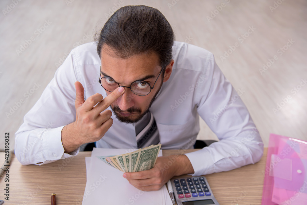 Young male bookkeeper in budget planning concept Young male bookkeeper in budget planning concept