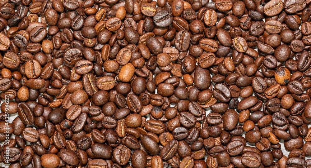 Fototapeta premium Roasted coffee beans on a flat background.