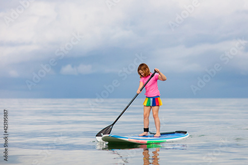 Child on stand up paddle. Water and beach sport © famveldman
