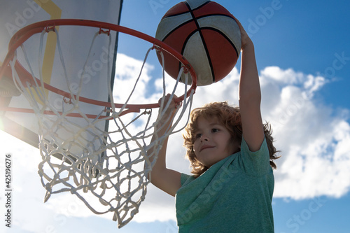 Healthy children lifestyle. Closeup face of kid basketball player making slam dunk.