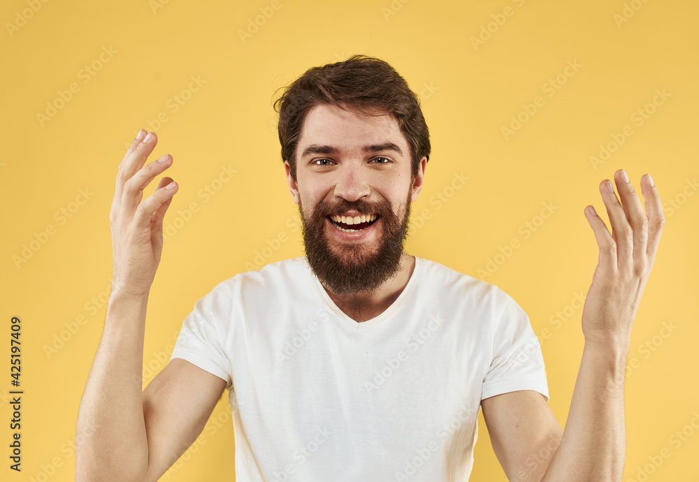 Energetic man raised his hands up and on a yellow background emotions model Energetic man raised his hands up and on a yellow background emotions model