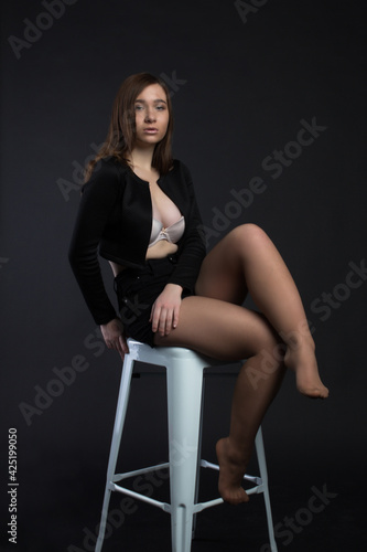 Young brown-haired woman, studio photo on a black background