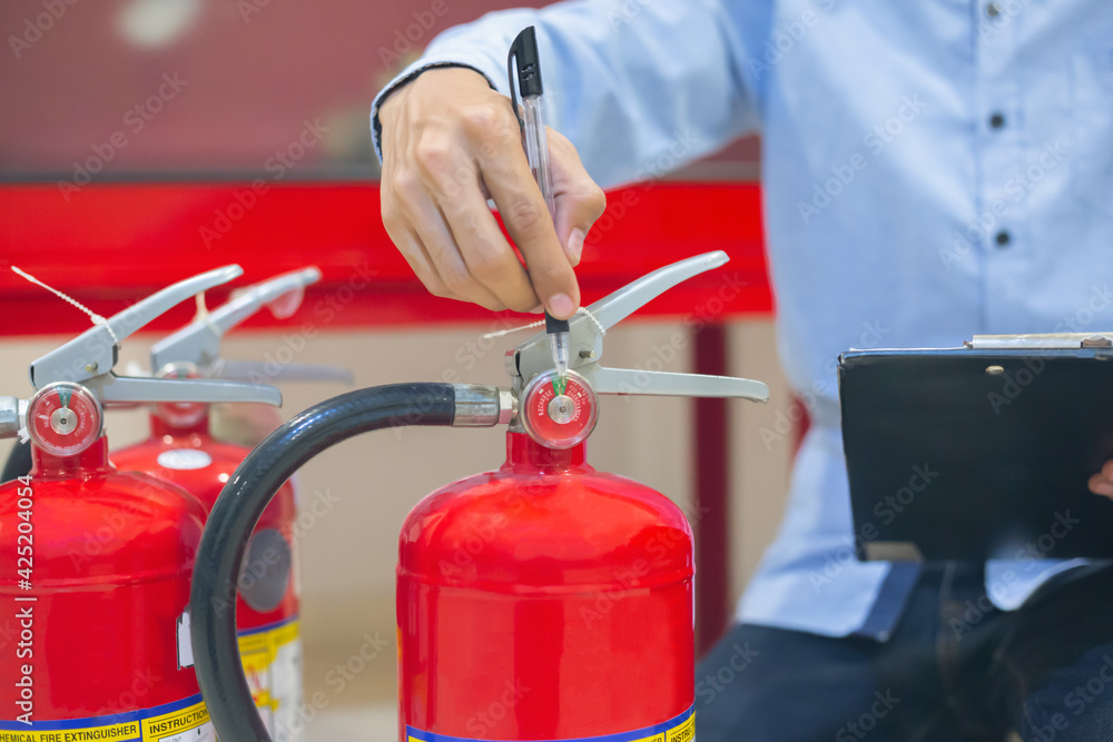 Expert engineers inspect fire extinguishers to be ready for use. Expert engineers inspect fire extinguishers to be ready for use.