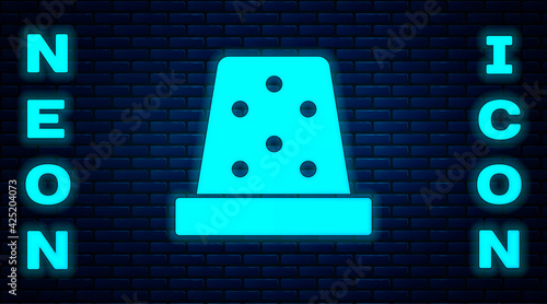 Glowing neon Thimble for sewing icon isolated on brick wall background. Vector