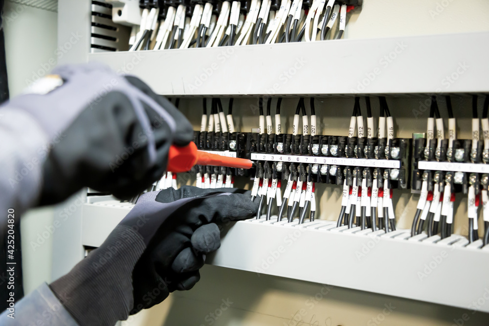 Electricians work to connect electric wires in the system, switchboard