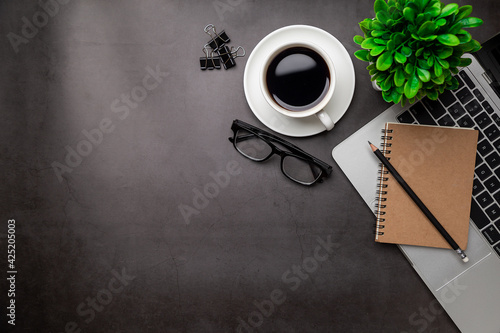 Top view desk,Modern office desk Workspace with laptop computer, coffee cup, glasses,notebook and office supplies for Working background concept.